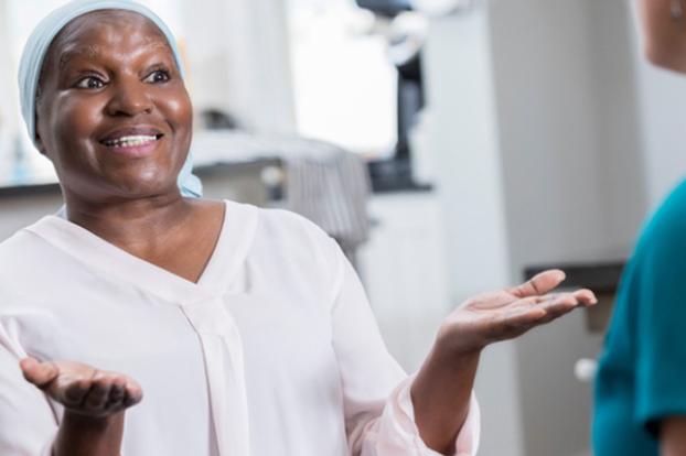 Oncology patient smiling with hands up.