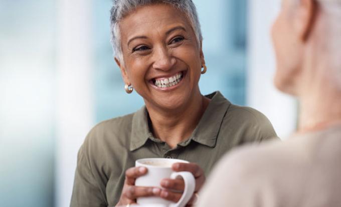 Two talk with coffee cups