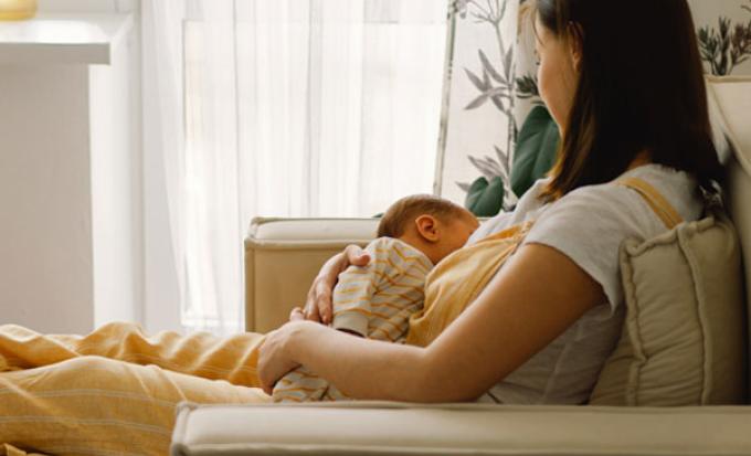 Mom in chair breastfeeding infant