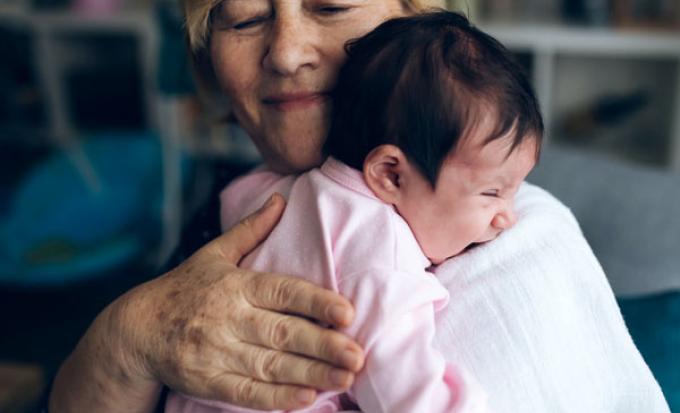 Grandparent burping newborn