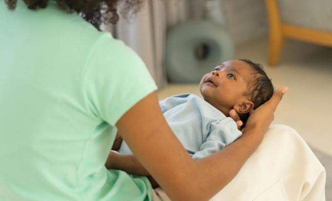 Gazing at newborn held on lap