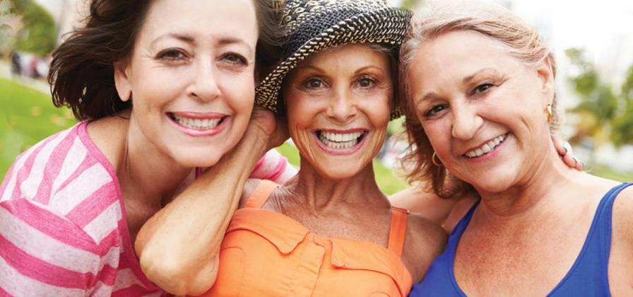 Cancer survivor in hat with two supportive friends. 