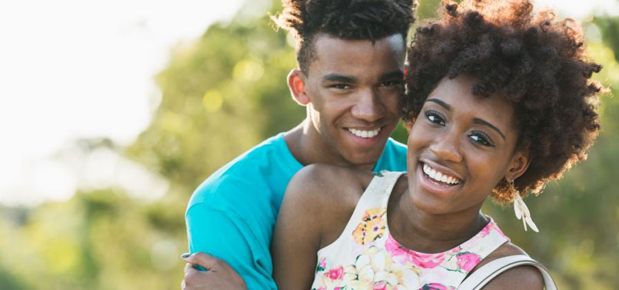 Young couple smiling outside