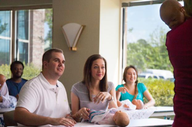 Classroom learning baby care with dolls.