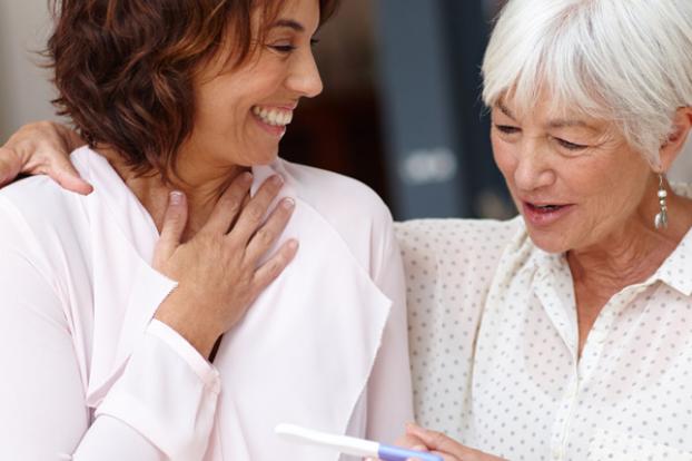 Expectant mom with pregnancy test and grandmother.