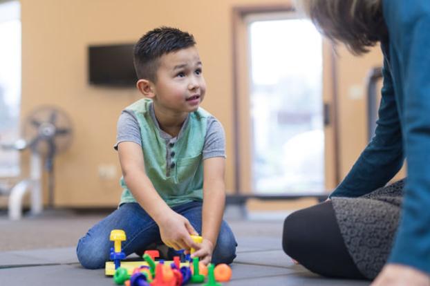 Child with puzzle and therapist.