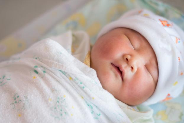 Newborn swaddled and sleeping.