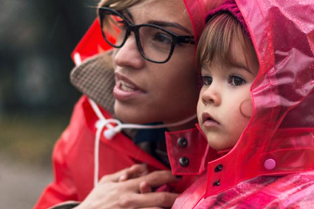 Mom and toddler looking out to the rain.