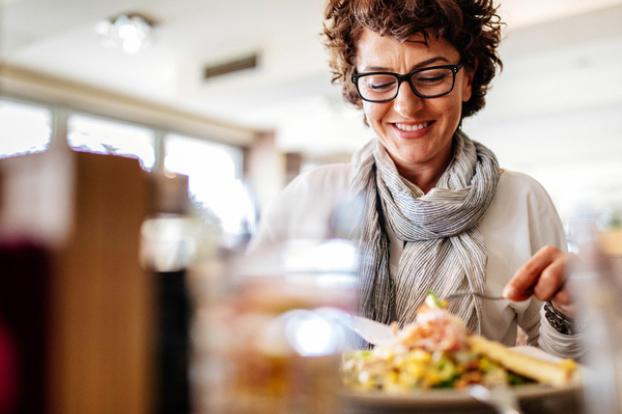 Cancer survivor eating at a restaurant counter.