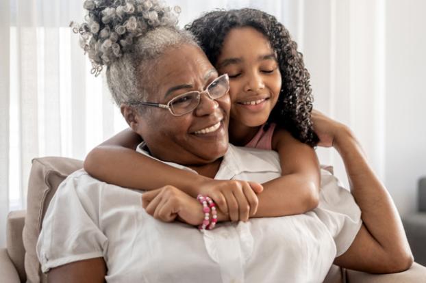 Grandchild sweetly hugs from behind.