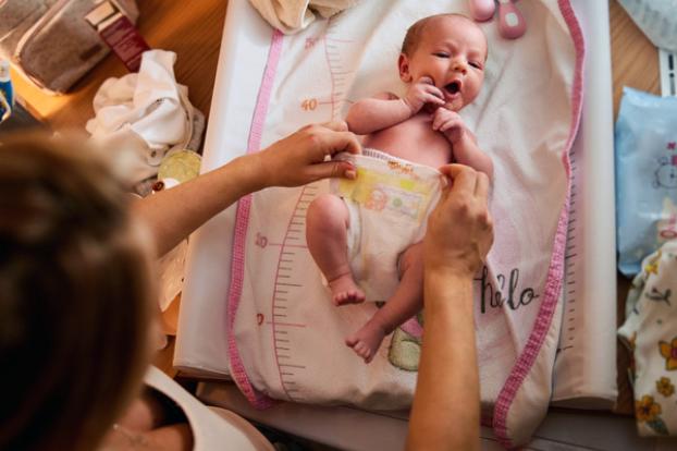 Infant having diaper changed