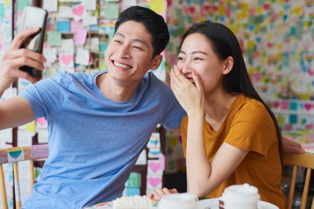 Couple take selfie near birthday cake.