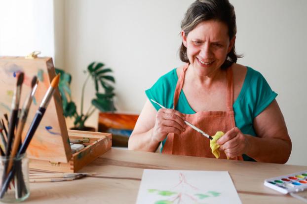 Painting with water colors at table.
